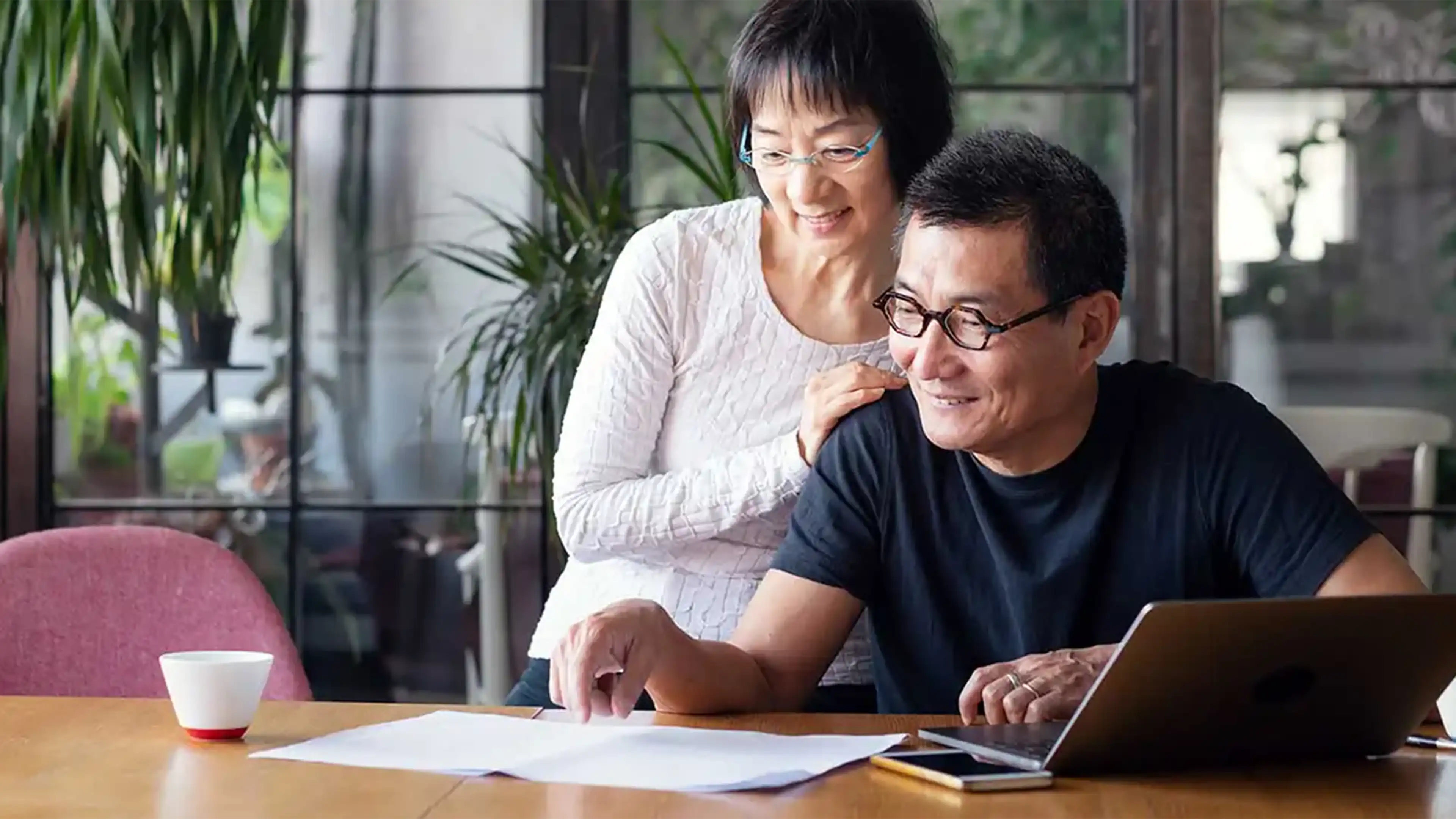 istock-11492787895fc8d50c55cf4dc1a59107cffcb0e723 happy couple looking at papers phone and laptop