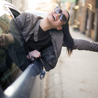 Happy woman leaning out of car