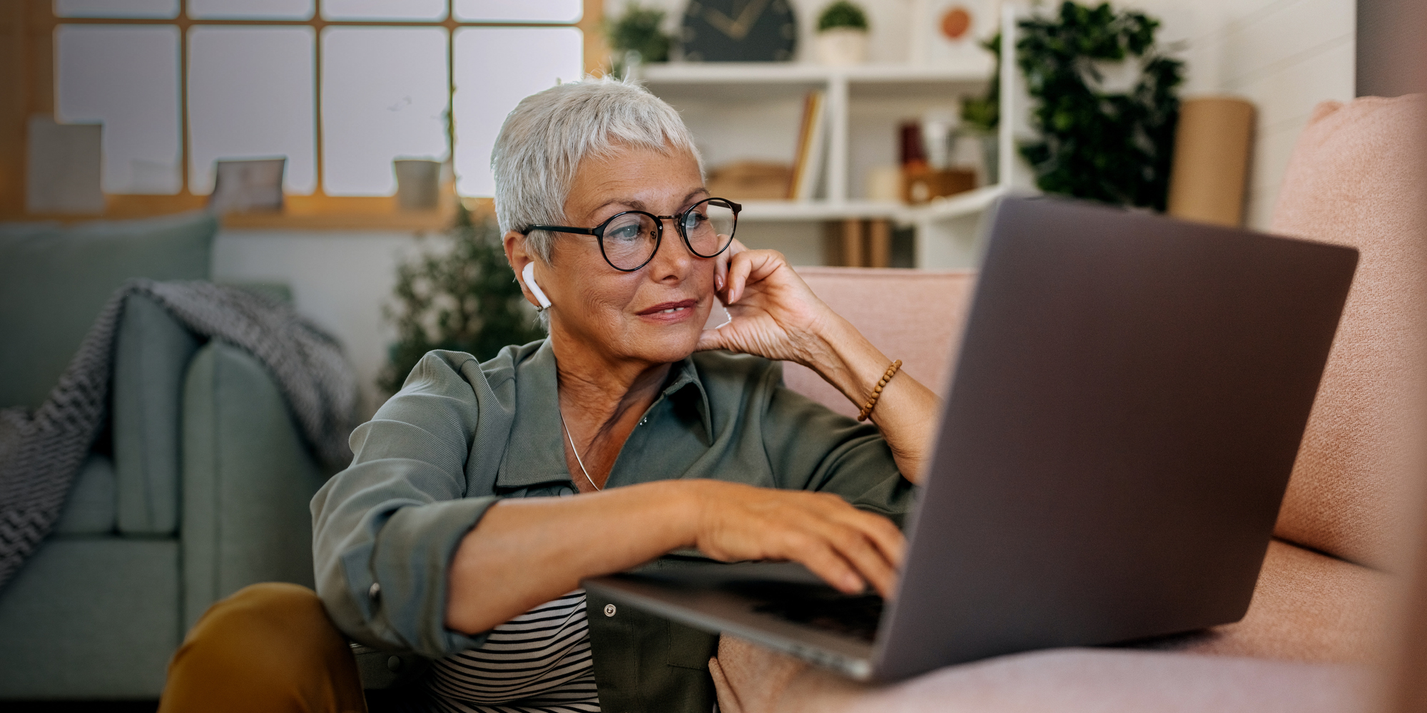 Woman in glasses using laptop to pay bills online at myconsumers.org