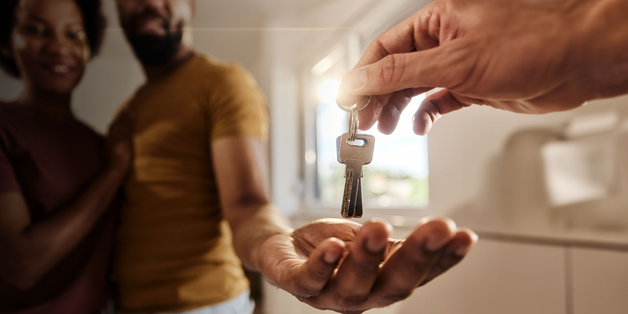 young couple being handed keys to new home
