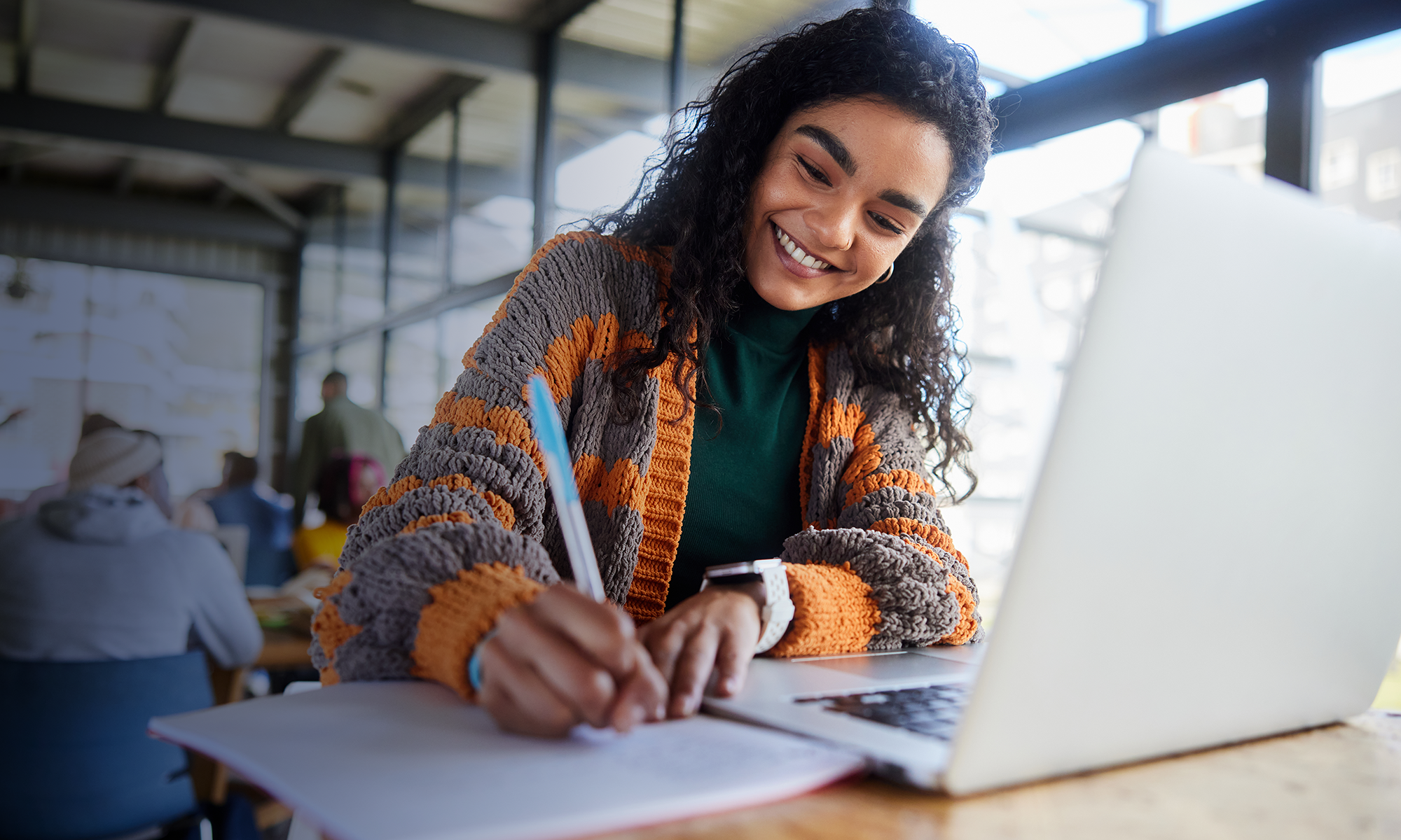 Young girl with laptop taking notes